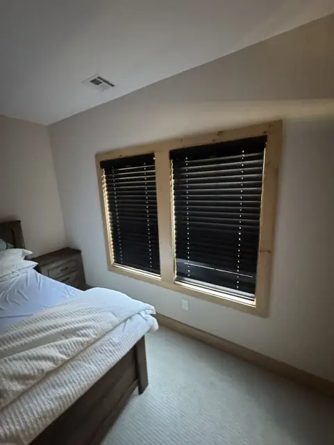 Dark wood blinds on two bedroom windows with natural pine trim