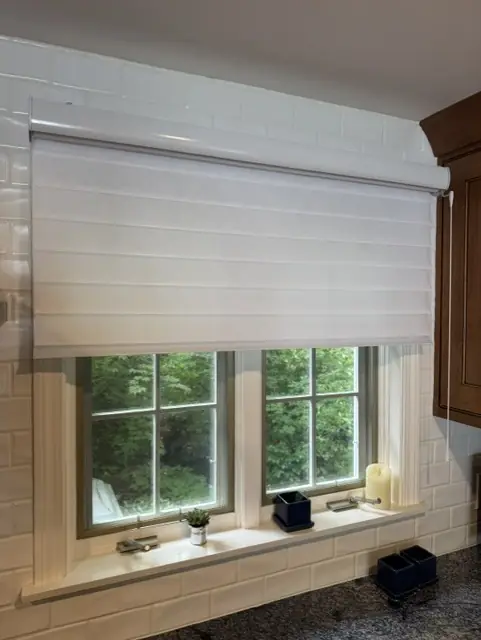 White sheer shading raised above a kitchen window with a subway-tile backsplash