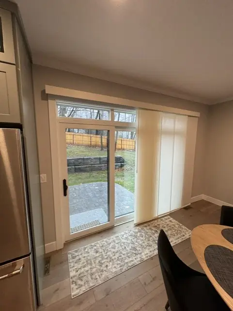 Panel shades stacked to one side of a sliding glass door