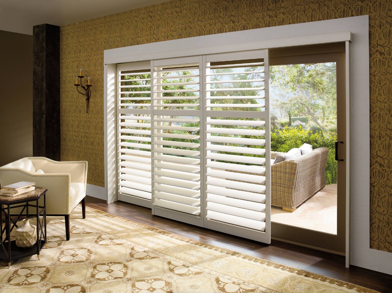 Hunter Douglas Palm Beach™ Polysatin™ Shutters decorating sliding glass doors in a modern living room near Windham, NH